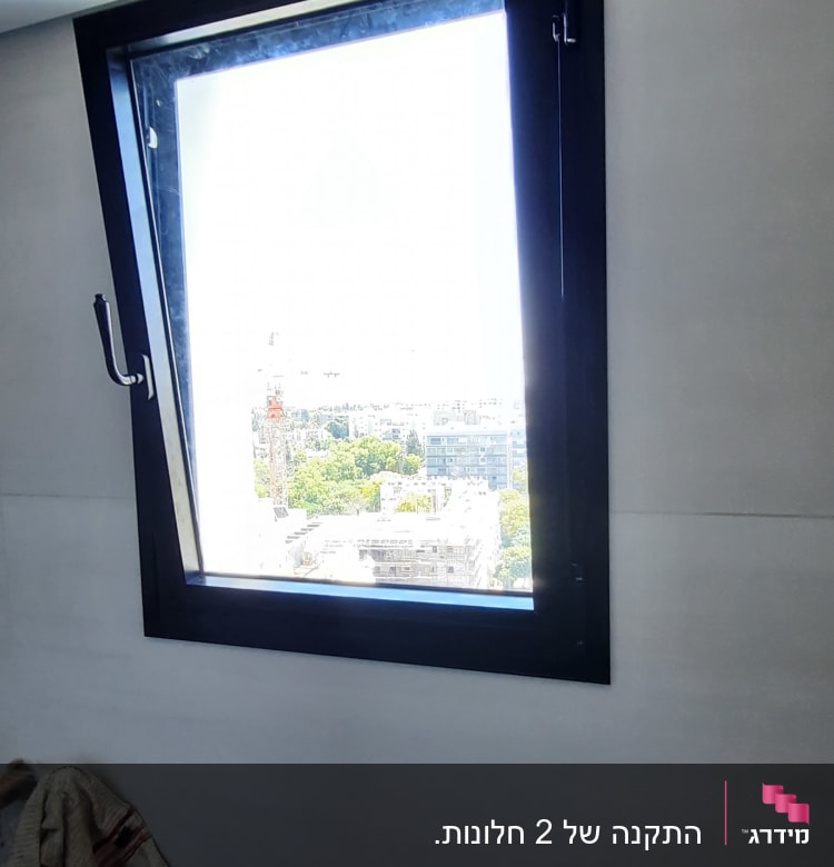 חלון אלומיניום עם מסגרת שחורה וקיר אפור